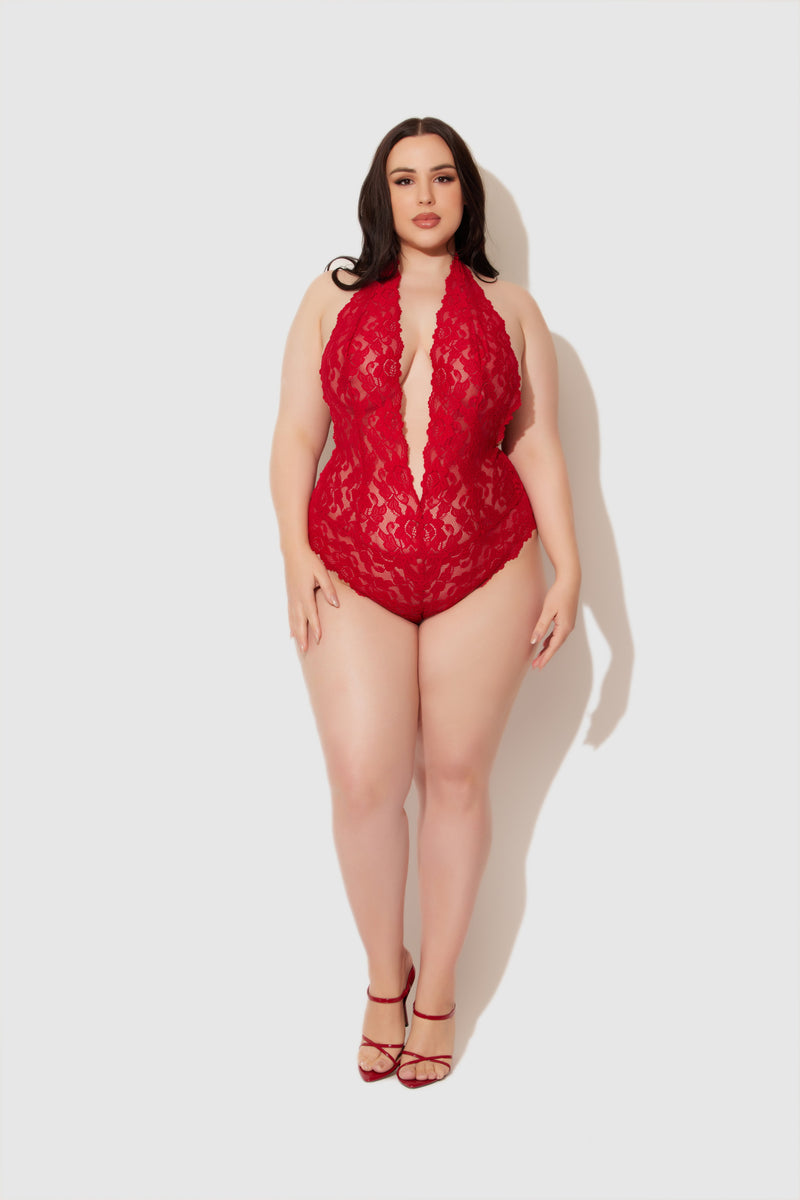 A woman with long dark hair wears the Jessica Lace Teddy by Frederick's of Hollywood and matching red heels, standing confidently against a plain light background.
