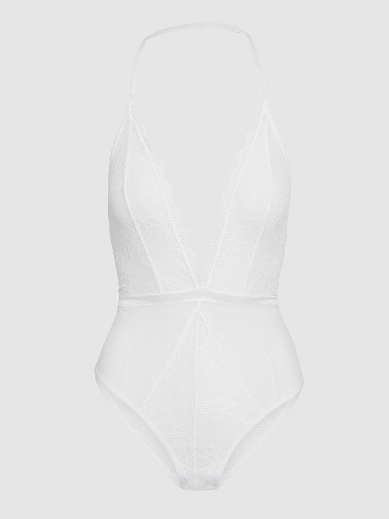 The Saffron Floral Lace Teddy by Frederick's of Hollywood is a white lace bodysuit with a deep V-neckline, thin adjustable straps, and sheer detailing, shown against a plain light gray background.