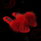 Red fluffy slippers on a black background with roses.
