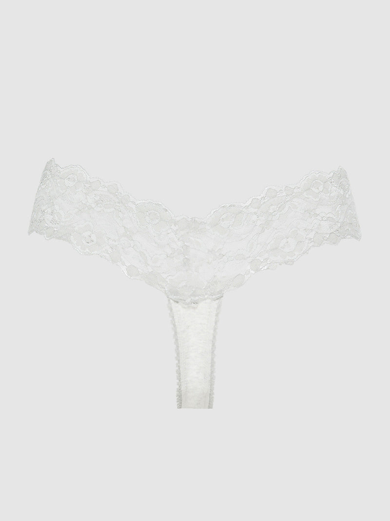 The Bridget Stretch Cotton & Lace Thong by Frederick's of Hollywood is shown against a light gray background, highlighting its wide floral lace waistband, minimal coverage, and elegant white design.