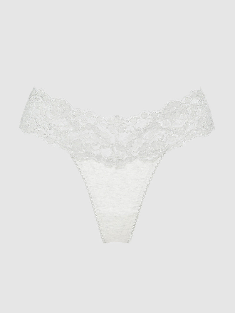 The Bridget Stretch Cotton & Lace Thong by Frederick's of Hollywood features a wide floral lace waistband and soft fabric, offering minimal coverage and all-day comfort. Displayed on a plain, light gray background.