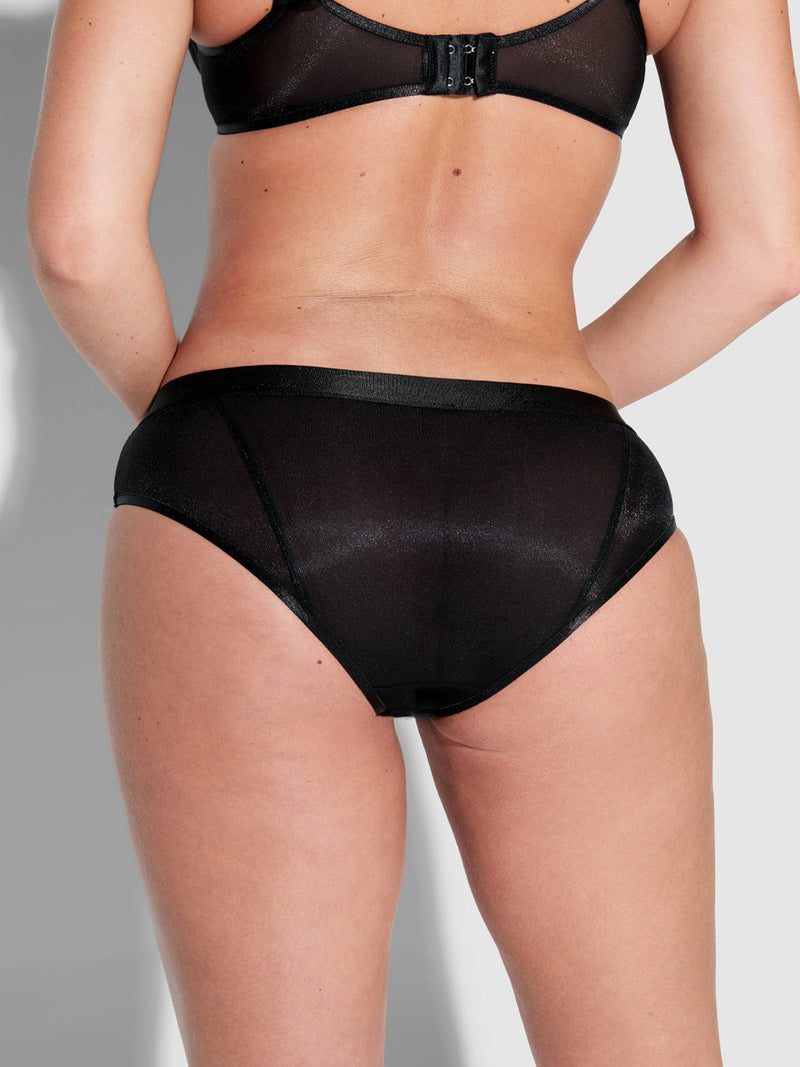 A person is shown from the back, wearing a black sheer bra and Frederick's of Hollywood Pia Mesh Hipster panties, standing against a plain light background.