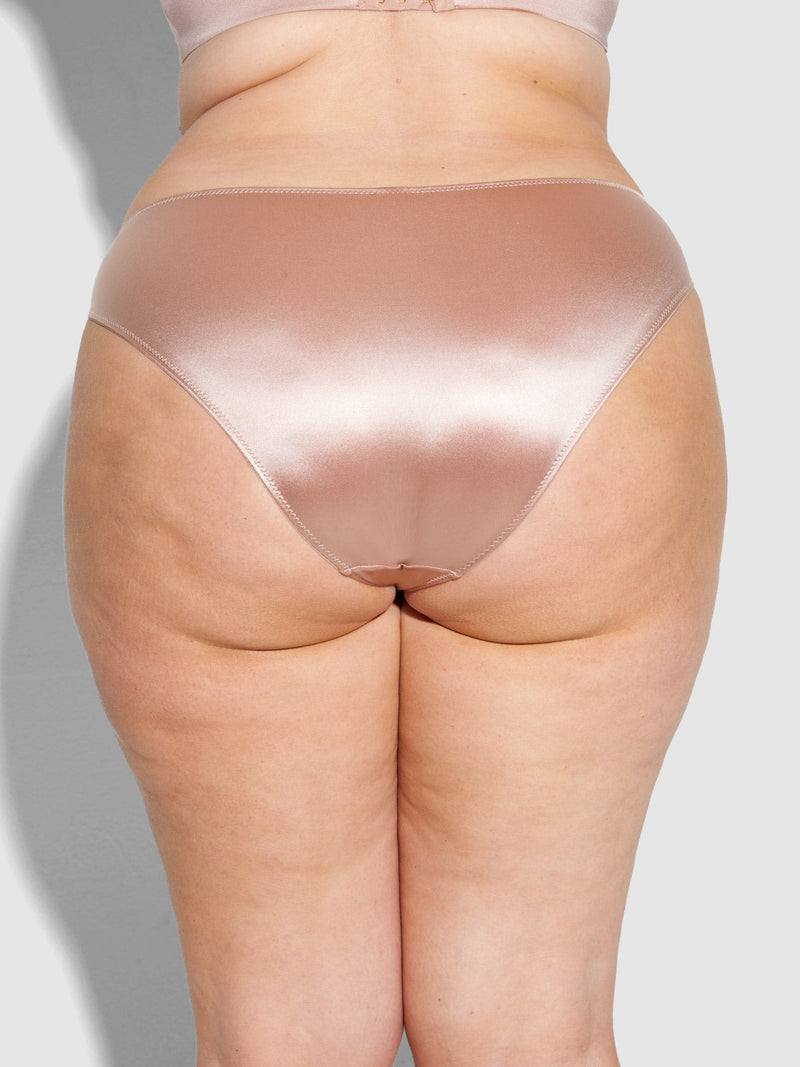 A person wearing Frederick's of Hollywood Lexi Liquid Satin Hipster underwear in shiny light pink, shown from the back, stands against a light gray background.