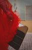 woman wearing pink lingerie and red robe, with sunglasses holding a suitcase